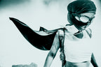 Person wearing a mask and cape in a superhero pose against a light background. burningman burning man 2013