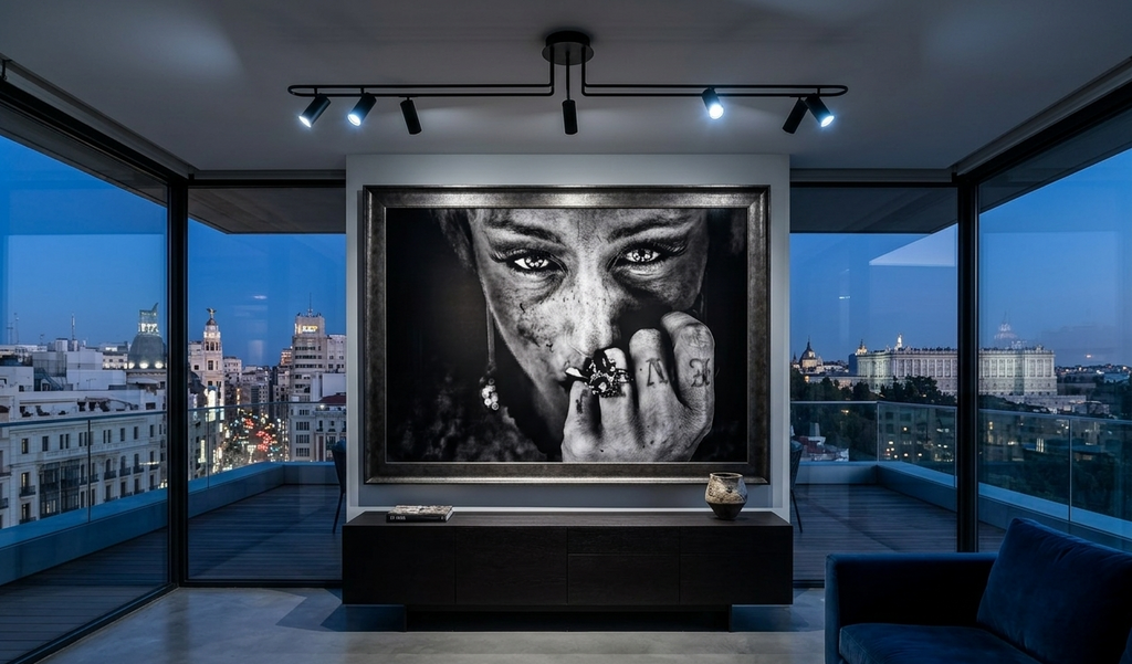 Modern living room with a large TV displaying a black and white image, overlooking a cityscape at night.